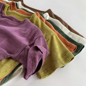Detailed close-up of textured slub cotton fabric and stitching on colorful kids t-shirts