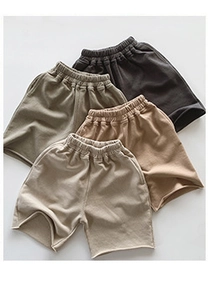 Close-up of four kids cotton drawstring shorts in earth tones with elastic waistband