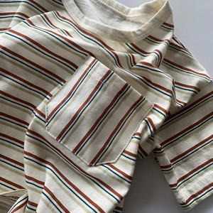 Détail de t-shirt en coton rayé pour enfants avec poche et col rond épais