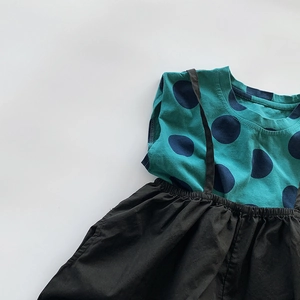 Detail of teal polka dot vest paired with black suspender skirt set for kids