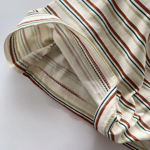 Détail du tissu en coton à rayures multicolores montrant une couture intérieure lisse et propre