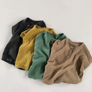 Flat lay of four colorful double-layer cotton gauze baby rompers with snap buttons
