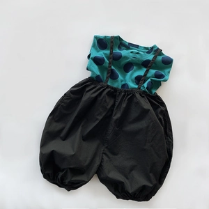 Flat lay of baby summer set with teal polka dot t-shirt and black suspender shorts