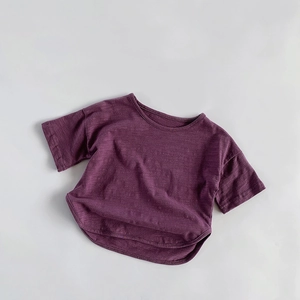 Detailed macro view of the breathable slub cotton texture on dark purple kids' t-shirt