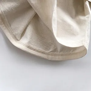 Nahaufnahme des Saumdetails eines Kinder-T-Shirts aus Baumwolle mit Naturstofftextur