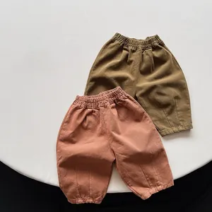 Détail de la taille élastique haute et de la texture plissée du pantalon enfant