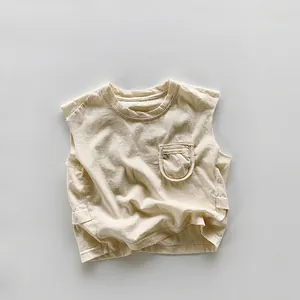 Détail d'un débardeur en coton crème pour enfants avec une petite poche sur la poitrine
