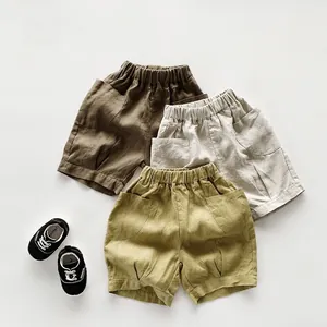 Détail de shorts rétro en lin pour enfants présentés en trois couleurs terreuses