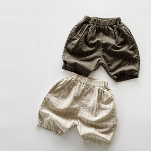 Dettaglio di pantaloncini a righe in lino per bambini in verde oliva e beige