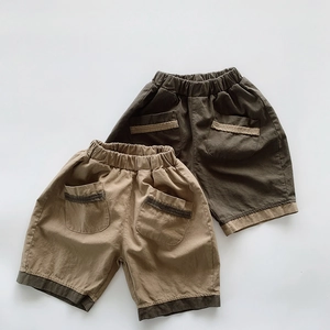 Détail de shorts en coton pour enfants avec taille élastique et poches à liseré contrasté