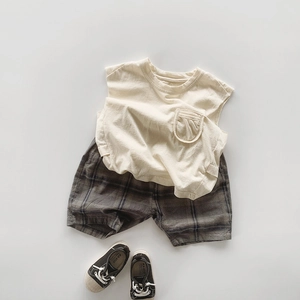 Mise à plat d'un t-shirt sans manches beige en coton et d'un short à carreaux enfant