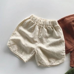 Close-up detail of breathable cotton linen texture and elastic waistband on kids' shorts