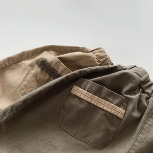 Détail de la taille élastique et des poches arrière rayées sur un short en coton enfant