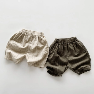 Dettaglio dell'elastico in vita e delle sottili strisce verticali sui pantaloncini in lino