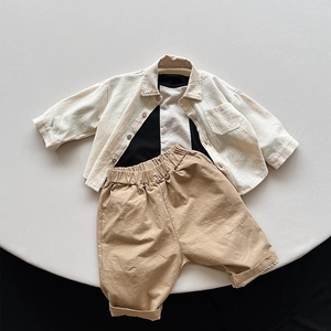 Flat lay of minimalist Japanese-style three-piece kids' set with linen shirt and shorts