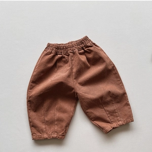 Détail du pantalon enfant rouge brique avec taille élastique et ourlet plissé doux