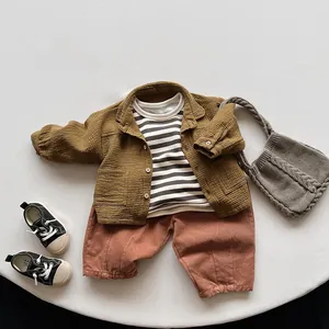 Détail à plat de la veste jaune moutarde avec T-shirt rayé et pantalon terre cuite
