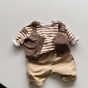 Flat lay of striped shirt, dark brown utility vest, and khaki shorts for toddlers