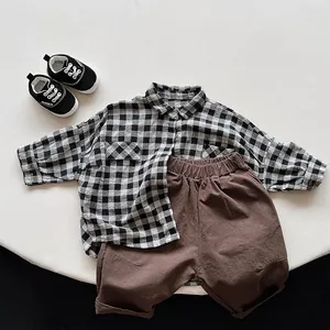 Détail à plat d'une chemise à carreaux en coton et lin avec short marron pour enfant