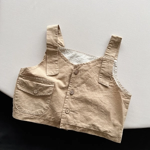 Detailed flat lay of beige linen kids vest with wooden buttons and a front flap pocket