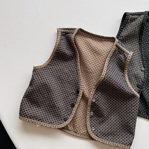 Detailansicht der gesteppten Wende-Kleinkinderweste mit Polka-Dots und Knopfverschluss