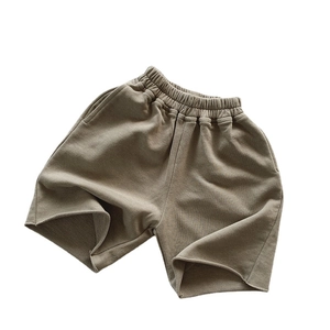 Breathable brown cotton shorts for children featuring an elastic waist and raw hem detail
