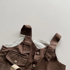 Detailed macro view of children's cotton linen vest with wooden button and big pocket