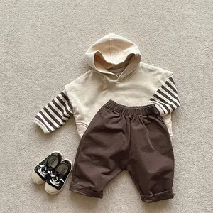 Minimalist beige hooded vest with striped sleeves and brown pants set for toddlers