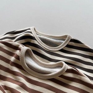 Détail du tissu en coton à rayures douces et du col en maille côtelée des pulls pour enfants