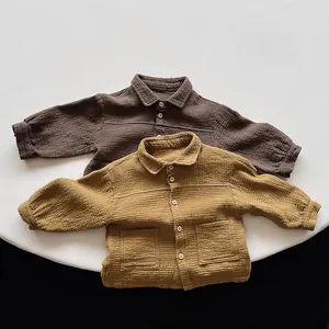 Detail of soft wrinkled cotton fabric and button pockets on kids long sleeve shirts