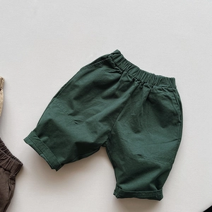 Détail de la taille élastique et des poches sur ce short décontracté vert foncé enfant