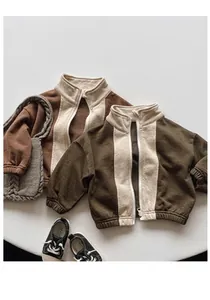Detailed view of color-block kids fleece jackets in brown and olive with ribbed cuffs