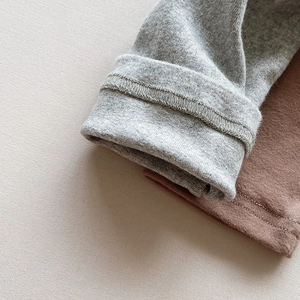 Close-up of high-quality cotton knit leggings cuffs showing fine stitching in grey and brown