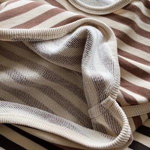 Détail du tissu French Terry en coton à rayures marron et blanc avec bord-côte soigné