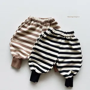 Close-up of striped kids' sweatpants with elastic waist and ribbed cuffs for autumn wear