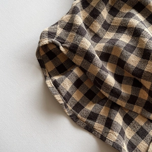 Gros plan sur la texture du tissu vichy et les détails de couture soignés de l'article