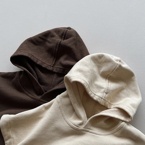 Detail of hooded vest necklines in brown and cream soft high-quality cotton fabric