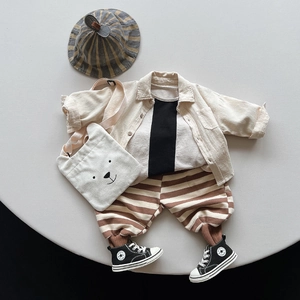 Flat lay of Korean style children striped pants with cotton shirt and bear bag