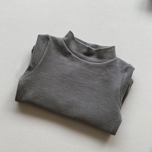 Close-up of soft brushed dark grey mock neck knit sweater for kids neatly folded