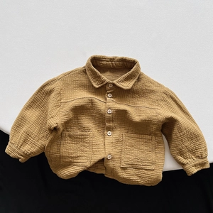 Detailed close-up of textured double gauze cotton fabric and buttons on kids' jacket