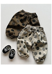 Flat lay of cotton infant trousers with polka dots in olive green and beige colors