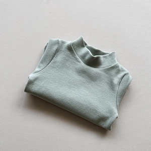 Detail view of the soft knitted texture and stitching on a sage green toddler thermal shirt