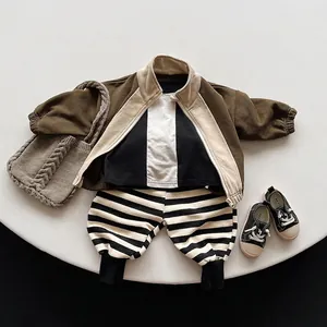 Kids three-piece set with earth-tone patchwork jacket and striped pants in flat lay