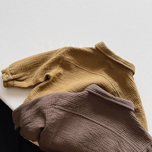 Detailed flat lay of mustard yellow and brown cotton jackets with textured waffle fabric