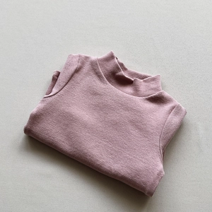 Detailed view of neatly folded dark pink mock neck knit sweater for kids in soft cotton