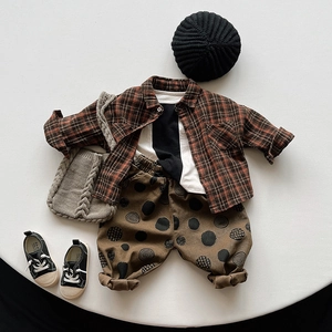 Three-piece kids outfit with plaid flannel shirt, white t-shirt and polka dot pants