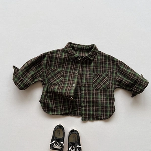 Detail view of the green plaid pattern texture and stitching on kids' long sleeve shirt