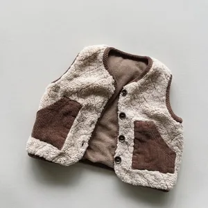 Dettaglio del gilet in pile per bambini con tasche a contrasto e bottoni marroni