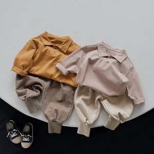 Close-up of kids cotton polo shirts and jogger pants sets with ribbed cuffs in earth tones