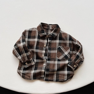 Close-up of vintage brown plaid flannel shirt with front pocket and button details